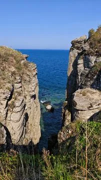 Dramatic coastal cliffs overlooking turquoise ocean Stock Photos