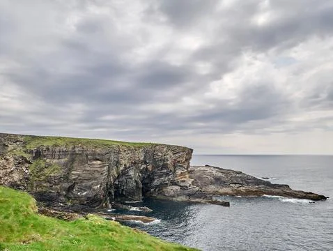 Dramatic Coastal Cliffs Under Cloudy Sky Foto stock