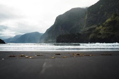 Dramatic Coastal Landscape with Dark Sand Beach, Rolling Waves, and Cloudy .. Stock Photos
