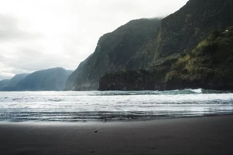 Dramatic Coastal Landscape with Dark Sand Beach, Crashing Waves, and Misty .. Stock Photos