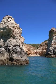 Dramatic coastal rock formations rising from the turquoise waters under a c.. Stock Photos