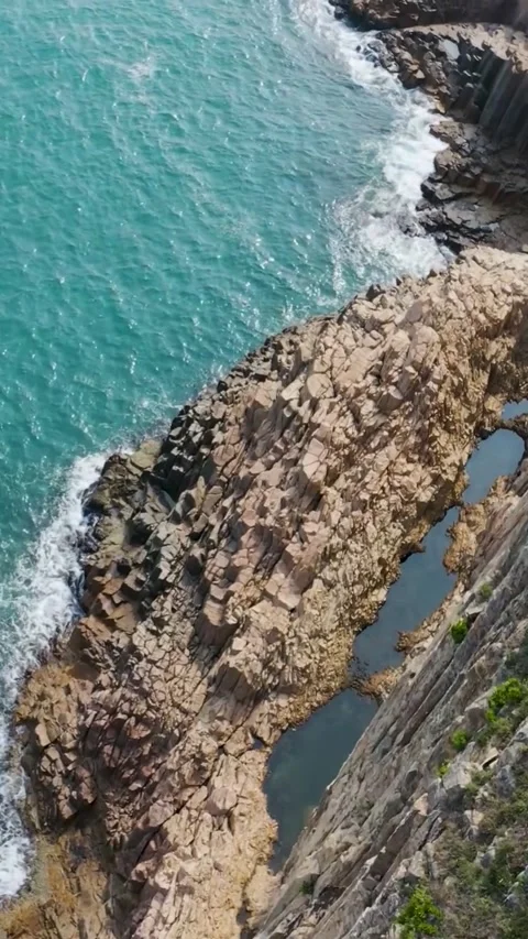 Dramatic coastal rock formations with waves crashing. 스톡 동영상 336335795
