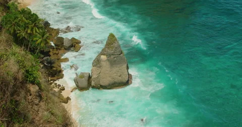 Dramatic Coastal Rock Peak Surrounded By Crashing Waves At Diamond Beach Bali In Video stock 327757261