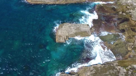 Dramatic Coastal Rocks Above Vibrant Blue Water Stock Footage 331624572