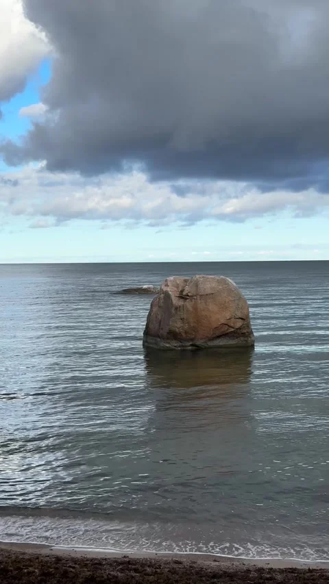 Dramatic Coastal Scene with Rock in Calm Sea under Stormy Sky Video stock 305370519