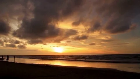 Dramatic Coastal Sunset with Figures on Beach Stock Footage 310244264