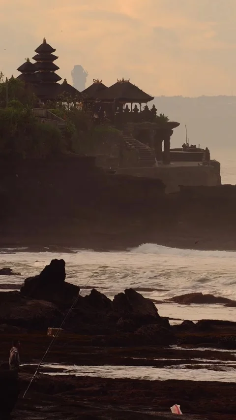 Dramatic Coastal View. Black Rocks And Fishermen Beneath Amber Sunset Glow Video stock 333646462