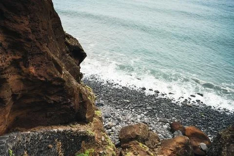 Dramatic Coastal View: Rugged Cliff Face Overlooking Rocky Shore and Crashi.. Stock Photos