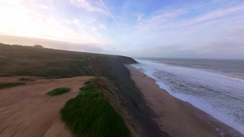 Dramatic coastline at dawn, waves breaking against cliffs Stock Footage 344677183
