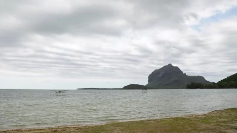A dramatic coastline under a moody sky, featuring a majestic mountain rising Stock Footage 319548301