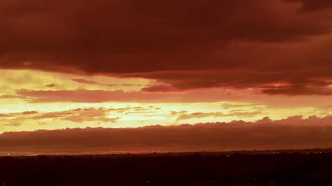 Dramatic colorful gold sunset with glowing orange clouds stretching across the 스톡 동영상 344029147