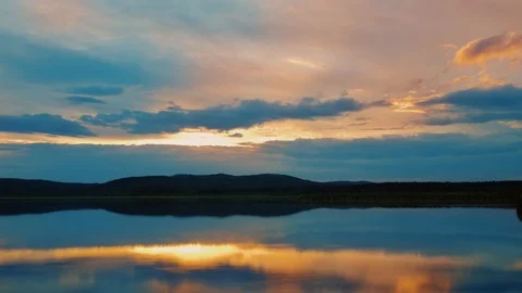 Dramatic colorful timelaps of sunset, fiery cloudy sky moving over lake Video stock 111276398