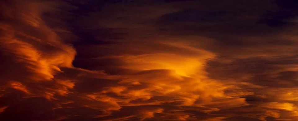 Dramatic colourful warm glowing clouds at sunset, Calgary, Alberta, Canada Stock Photos