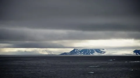 A dramatic contrast of dark stormy clouds and icy mountain slopes as they meet Video stock 312207931