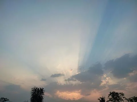 Dramatic Crepuscular Rays Bursting Through Clouds at Tropical Sunset Stock Photos