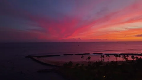 Dramatic crimson sunset over Magic Island lagoon and ocean in Honolulu 1 Stock Footage 346427895