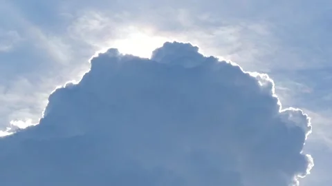 Dramatic cumulus cloud with bright sun flare rim lighting highlighting silh.. Stock Footage 345198269