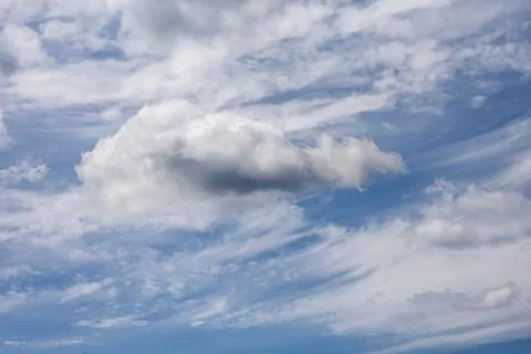 Dramatic cumulus cloud formation against a bright blue sky with wispy cirru.. Stock Photos