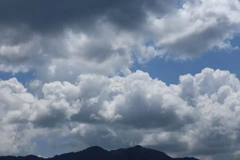 Dramatic Cumulus Clouds Above Mountain Ridge Under Daylight Sky Stock Photos