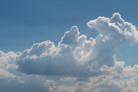 Dramatic cumulus clouds against a blue sky with soft sunlight Stock Photos