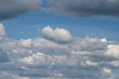 Dramatic cumulus clouds against blue sky with layered cloudscape Stockfoto's