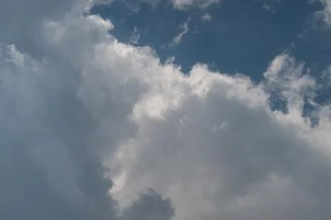 Dramatic cumulus clouds against blue sky with soft sunlight Stock Photos