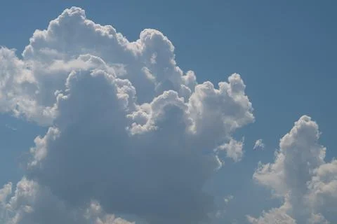 Dramatic cumulus clouds against clear blue sky Stock Photos