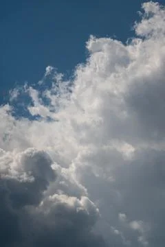 Dramatic cumulus clouds against deep blue sky with sunlit edges Stock Photos