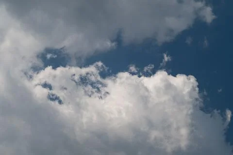 Dramatic cumulus clouds against deep blue sky Stock Photos