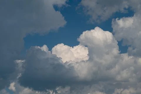 Dramatic cumulus clouds against deep blue sky Stock Photos