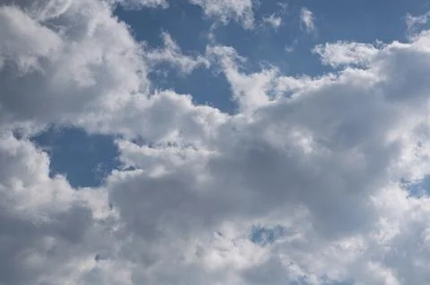 Dramatic cumulus clouds in bright blue summer sky background Stock Photos
