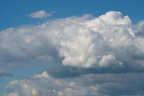 Dramatic cumulus clouds filling a blue sky with soft sunlight Stock Photos