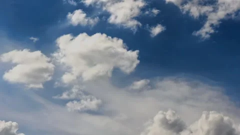Dramatic cumulus clouds move across a deep blue summer sky in time lapse Stock Footage 344881101