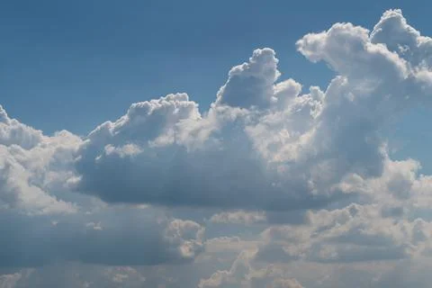 Dramatic cumulus clouds over blue sky with sunlit edges Stock Photos