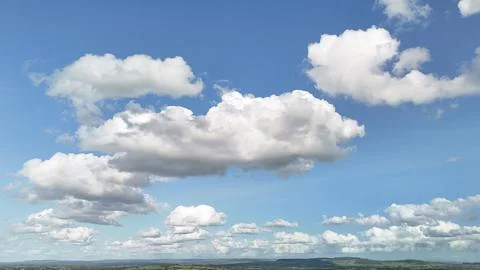 Dramatic Cumulus Clouds Over Green Countryside and Distant Hills Foto stock