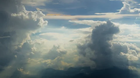 Dramatic Cumulus Clouds Over Mountain Silhouettes with Golden Sunlight Rays. Stock Footage 338361068