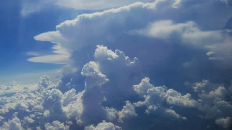 Dramatic Cumulus Clouds Viewed from Above During Flight Through Blue Sky. Stock Footage 338361918