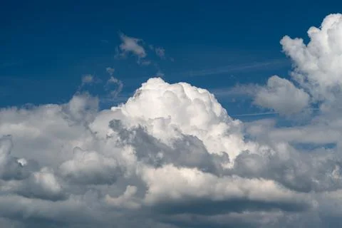 Dramatic cumulus cloudscape against deep blue sky Stockfoto's