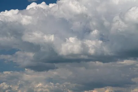 Dramatic cumulus cloudscape with sunlight and deep blue sky Stock Photos
