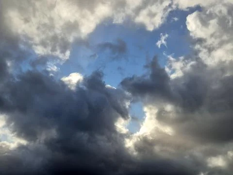 Dramatic dark and bright clouds with rays of sunlight Stock Photos