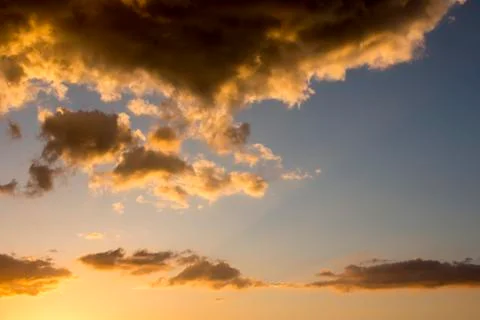 Dramatic dark and orange clouds in clear sky during sunset. Spectacular natural Stock Photos