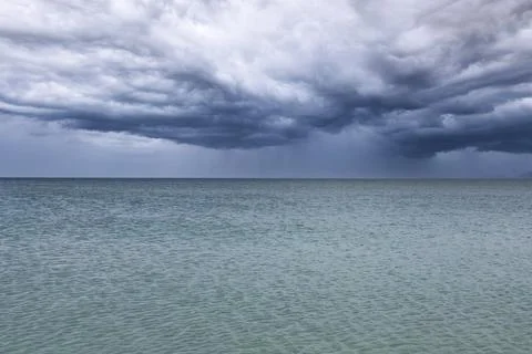 Dramatic dark blue storm clouds and rain over the sea. Black Sea. Stock Photos