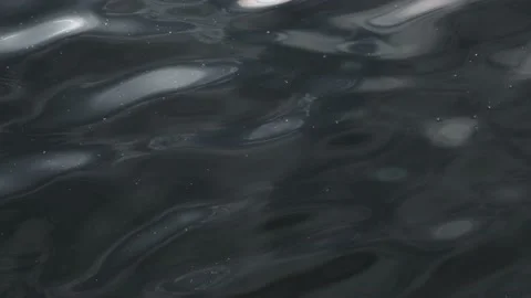 Dramatic dark blue water surface wave sun light vibrant glow closeup. Stormy Stock Footage 188568047