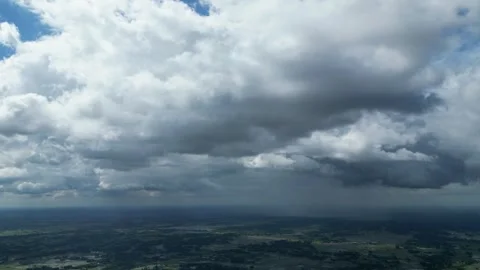 Dramatic dark clouds and rain shafts over green rural landscape aerial view Stock Footage 341936396