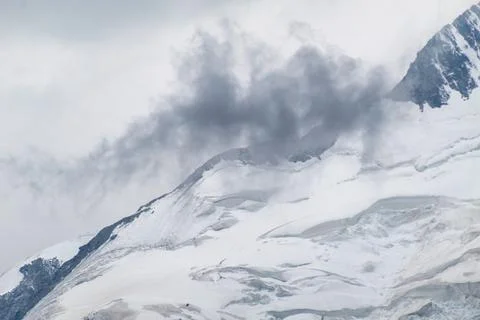 Dramatic Dark Clouds Over Snowy Alpine Glacier Peak Foto stock