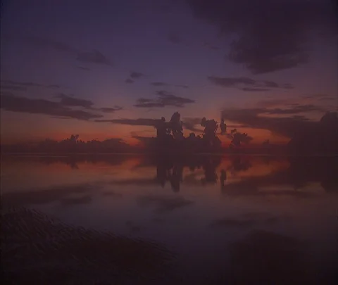 Dramatic dark clouds reflected in pink and orange still water Stock Footage 86747546