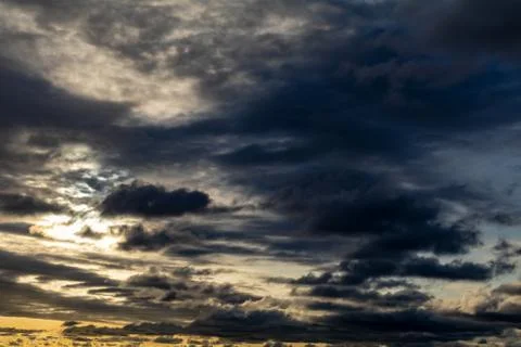 Dramatic dark clouds in the sky at sunset Stock Photos