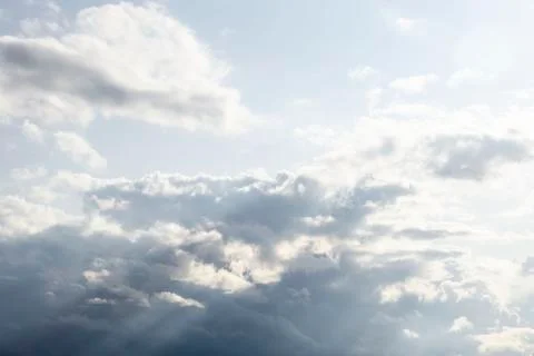 Dramatic dark cloudy sky, white and gray cumulus clouds moving across the blu Stock Photos