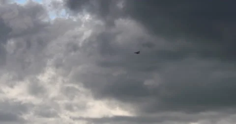 Dramatic dark grey rain storm clouds seagull bird flying slow motion Stock Footage 154335919