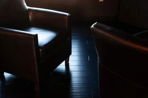 Dramatic dark lighting on comfortable office chair Stock Photos